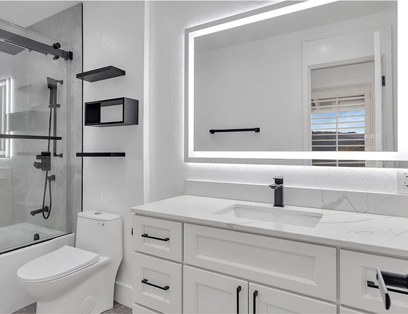 All-white bathroom where the mirror is contoured by a square light.
