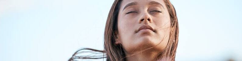 Woman with her eyes closed enjoying the breeze