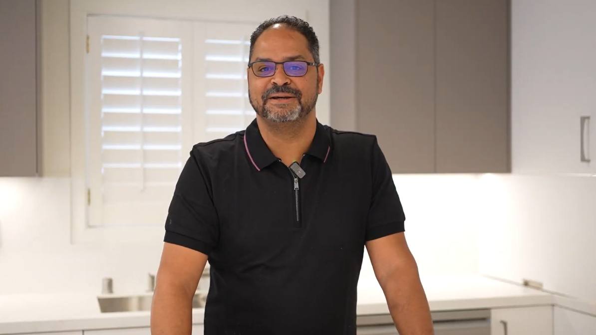 Man standing in his kitchen giving a video testimonial